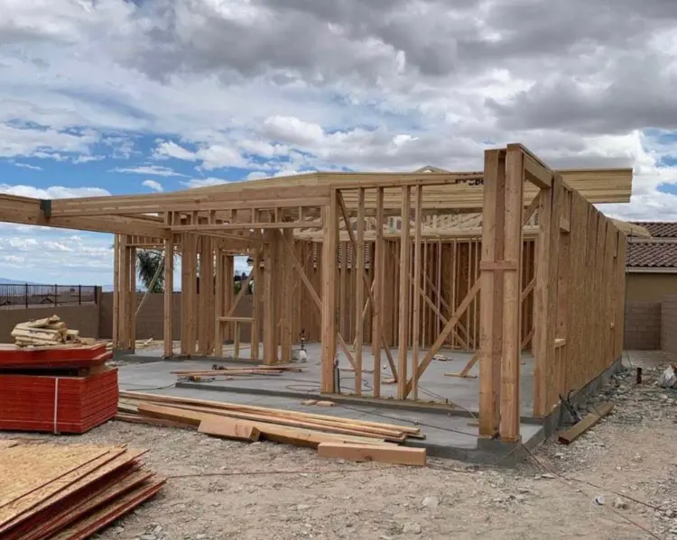 Wooden structural framing for a residential home on a concrete slab foundation at a new construction site.